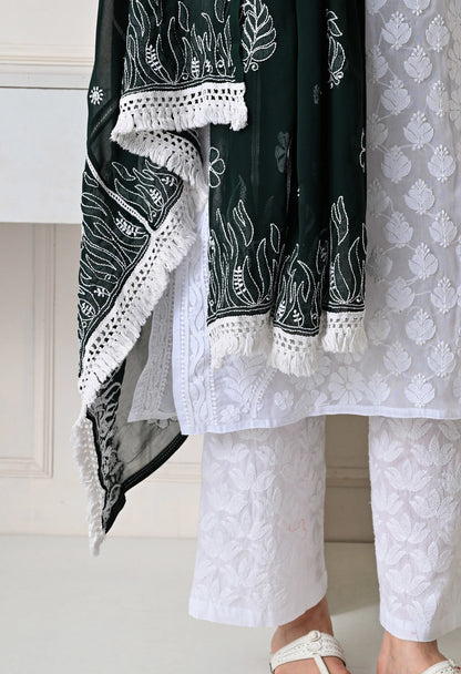 Black and white embroidered traditional outfit with white pants on a neutral background