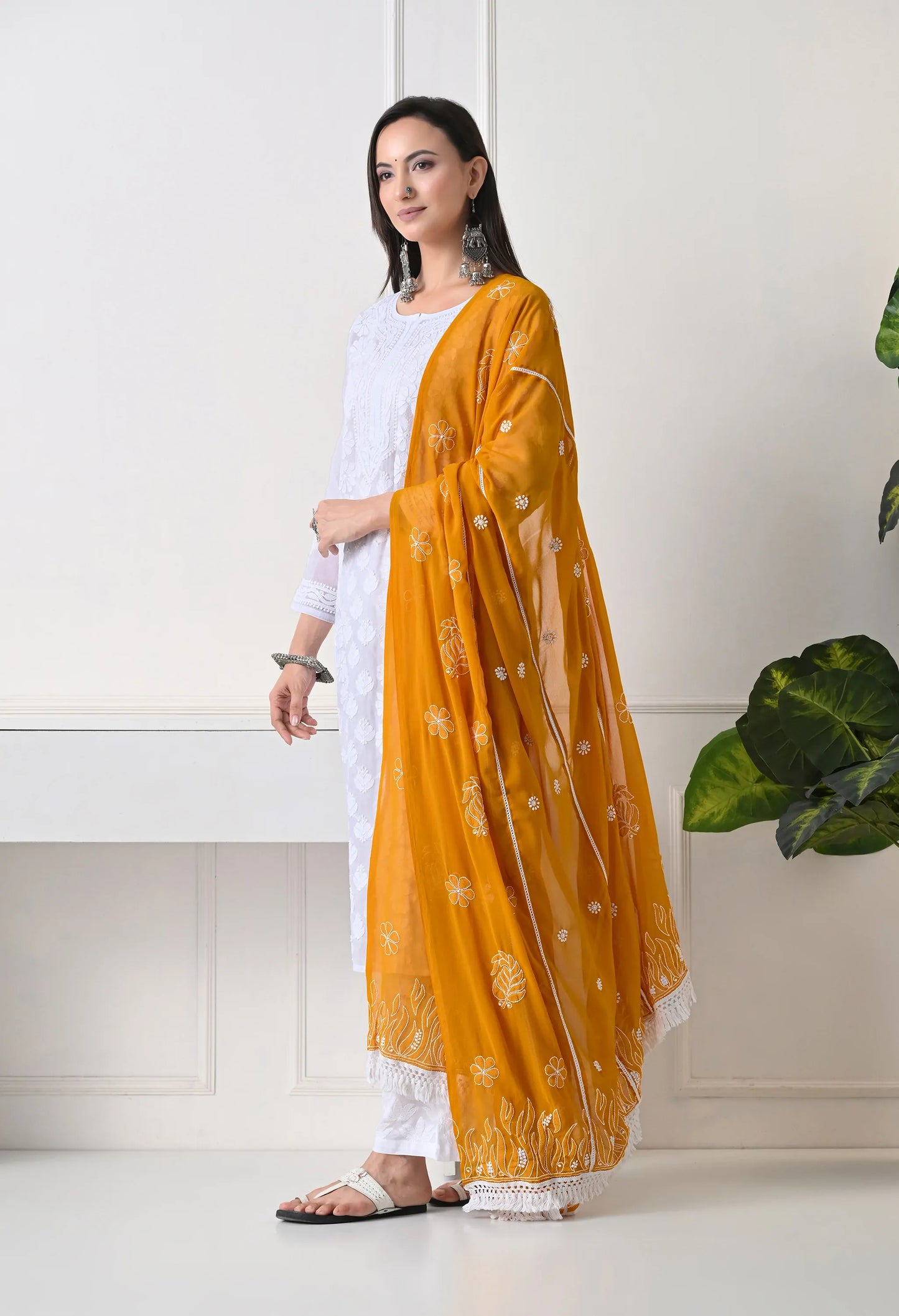 Mustard embroidered dupatta on traditional white outfit with white pants on a neutral background side view