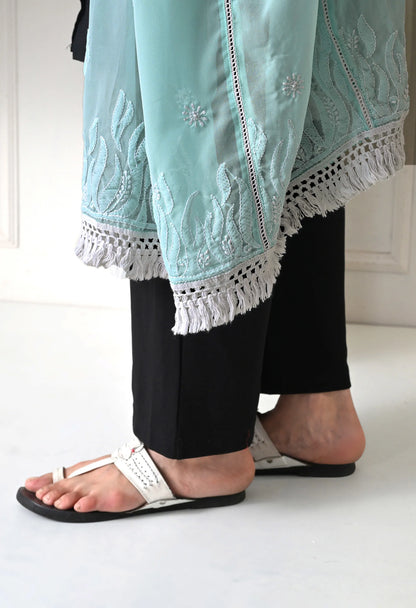 Woman wearing a mint green embroidered dupatta over a black outfit against a plain background