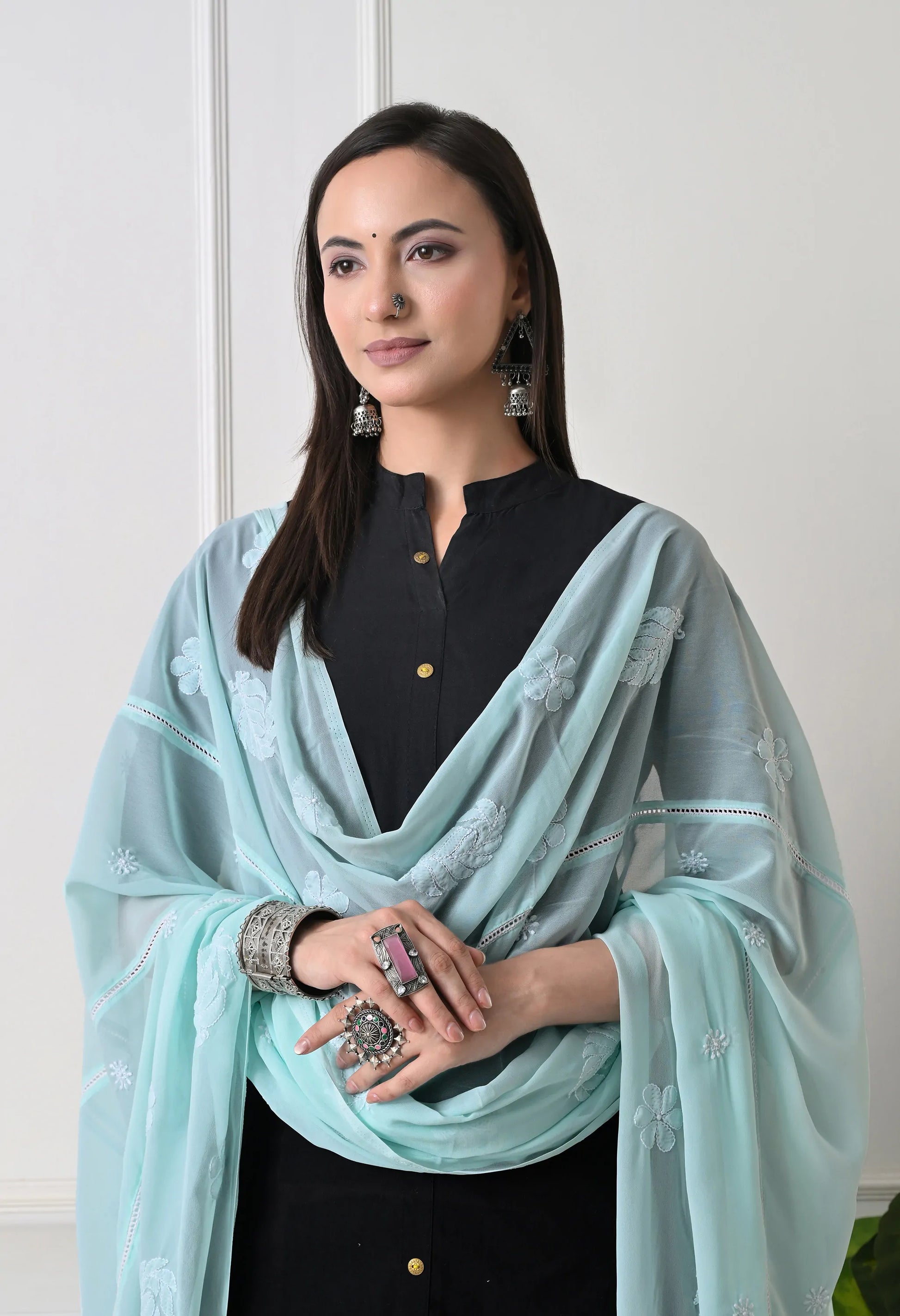Woman wearing a mint green embroidered dupatta over a black outfit front view.