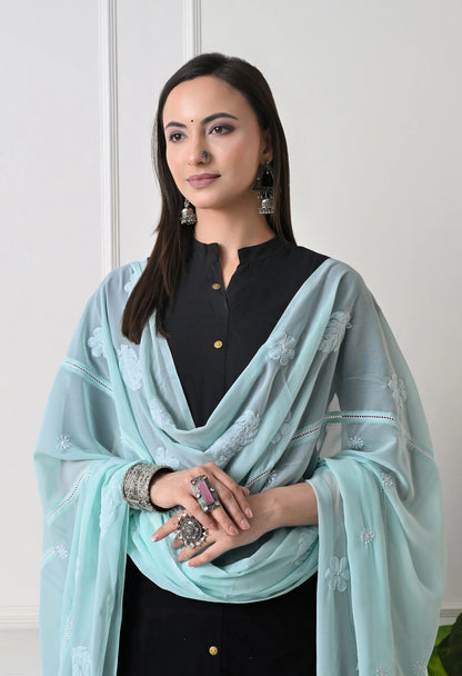 Woman wearing a mint green embroidered dupatta over a black outfit front view.