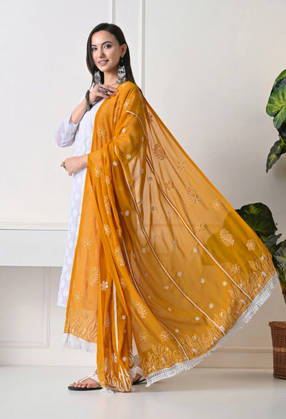 Woman wearing a mustard yellow dupatta with white patterns on a white background