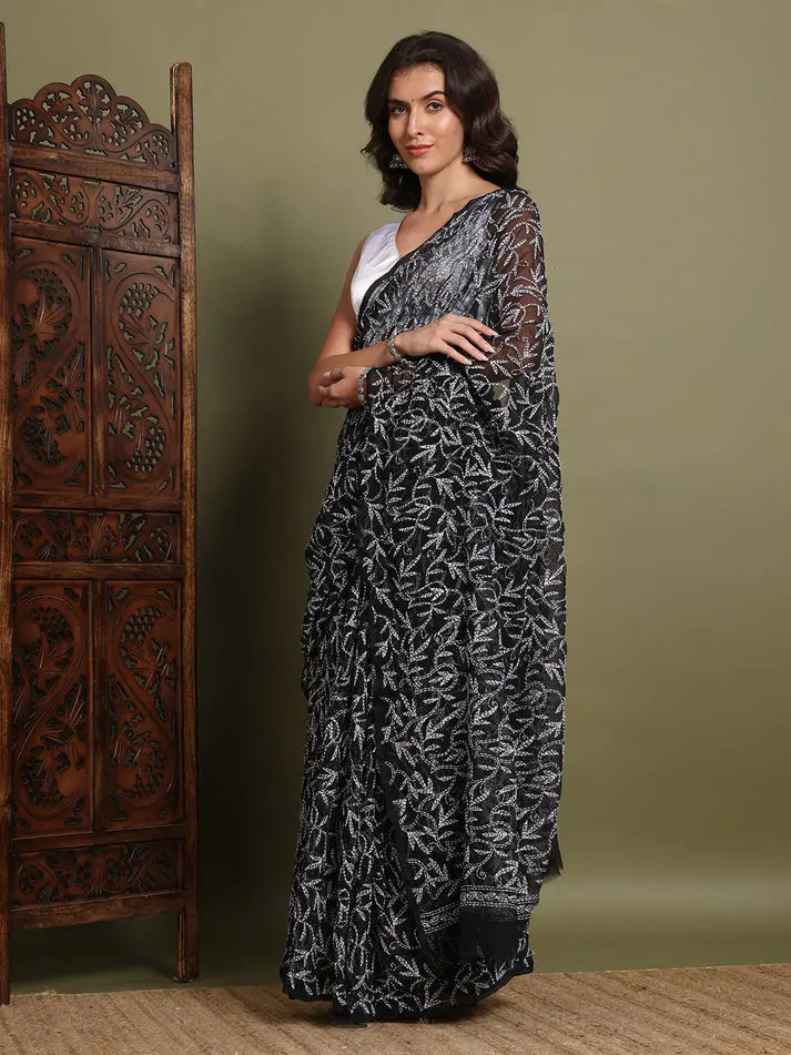 Angled view of exclusive black hand-embroidered Tepchi Chikankari saree