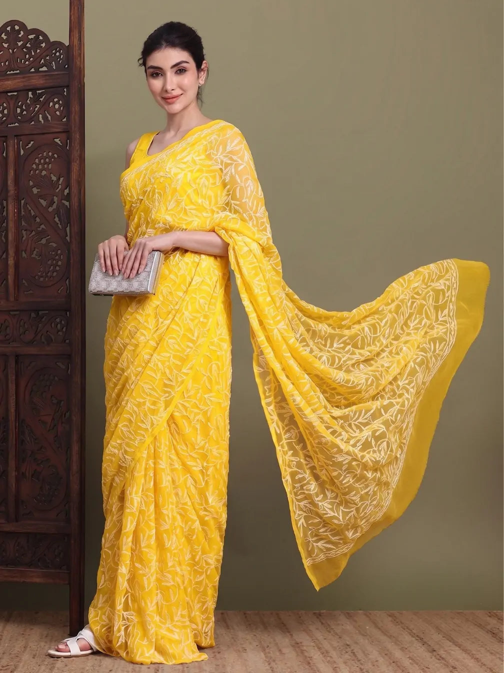 Angled view of exclusive dark yellow Tepchi hand-made Chikankari saree for women