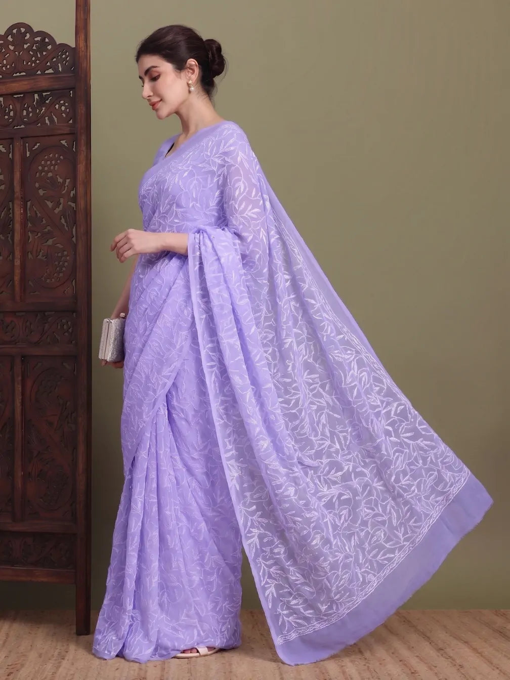 Angled view of exclusive light lavender hand-embroidered Tepchi Chikankari saree