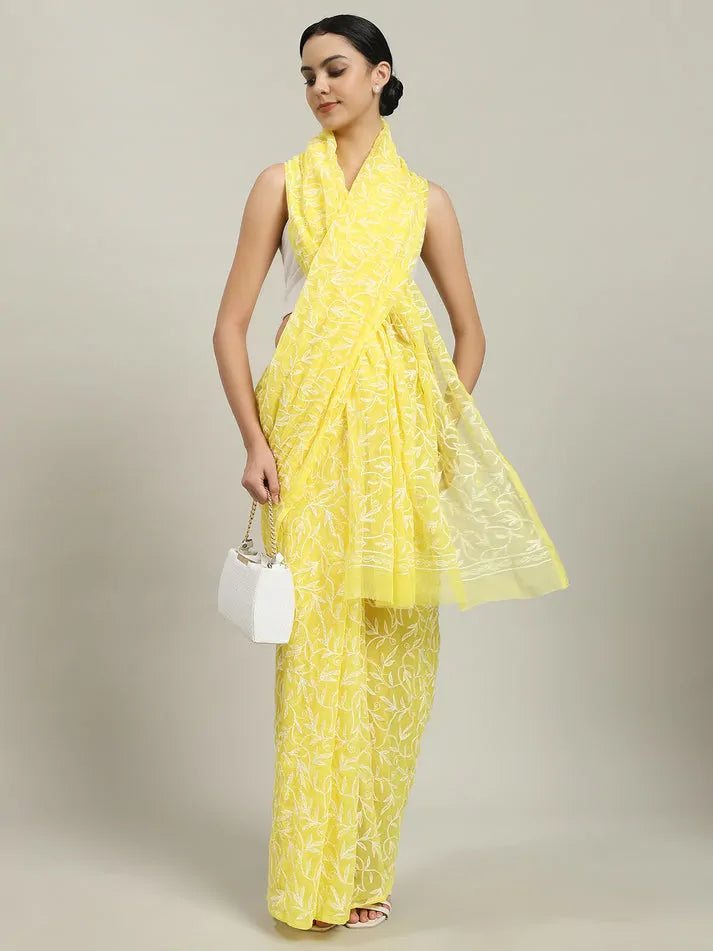 Lifestyle view of women wearing exclusive yellow Tepchi hand-made Chikankari saree