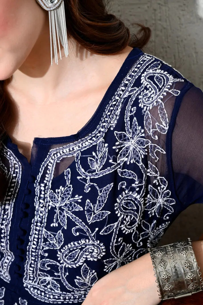 Closeup of intricate white embroidery on navy blue women's kurti