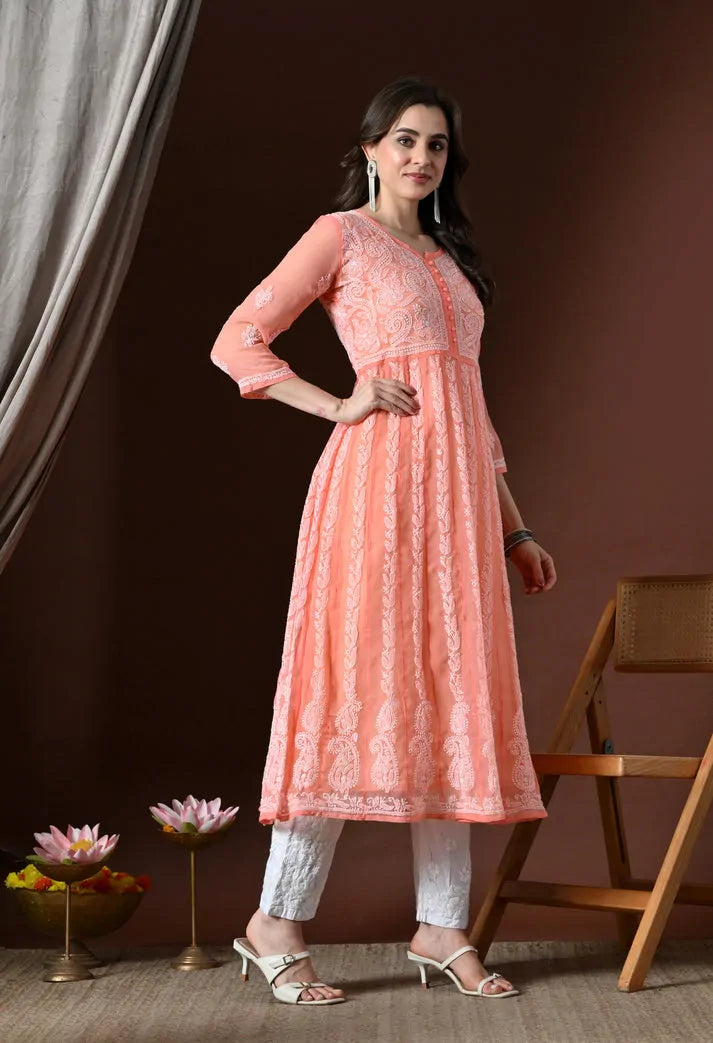 Angled view of peach floral embroidered anarkali kurta with white pants